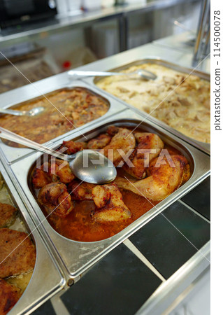 Bustling Cafeteria Serving Line During Lunchtime Offering a Variety of Dishes 114500078