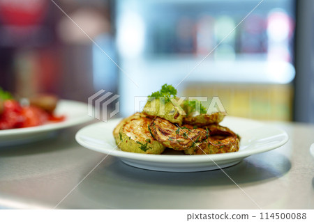 Grilled Zucchini Slices Served on a White Plate in a Modern Kitchen Setting Grilled Zucchini Slices Served on a White Plate in a Modern Kitchen Setting 114500088