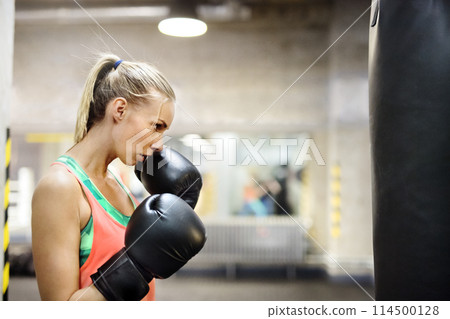 Beautiful sport woman doing box as cardiovascular training. Routine workout for woman's physical and mental health. 114500128