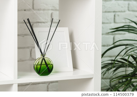 Elegant Reed Diffuser on White Shelf in a Modern Minimalist Interior Setting 114500379