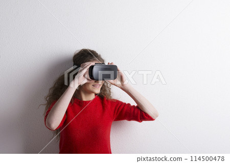 Young teenage girl with VR headset. Virutal reality, VR technology. Studio shot on white background with copy space. Young teenage girl with VR headset. Virutal reality, VR technology. Studio shot on white background with copy space. 114500478