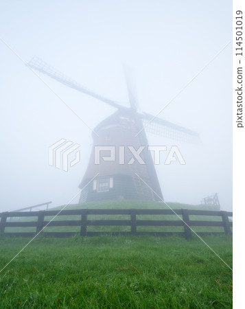 Landscape with windmill during fog. Holland. Dawn during a thick fog.  114501019