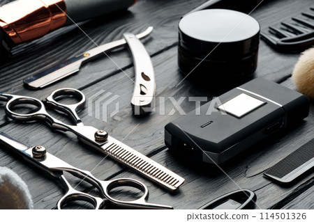 Professional Barber Tools Laid Out on Dark Wooden Surface Professional Barber Tools Laid Out on Dark Wooden Surface 114501326