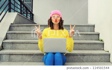 Portrait of modern cool young woman with laptop in the city Portrait of modern cool young woman with laptop in the city 114501544