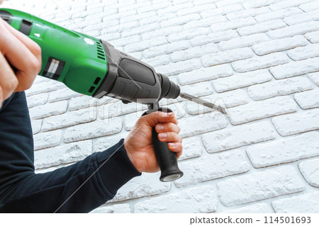 Use hammer drill to drill the wall 114501693