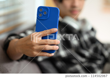 Select focus on hand of hipster man holding smartphone, scrolling and texting in social networks Select focus on hand of hipster man holding smartphone, scrolling and texting in social networks 114502067