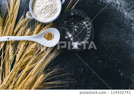 Wheat ears and flour on black background 114502741