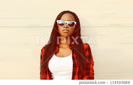 Portrait of stylish young african woman posing in casual clothes, sunglasses on white background 114503069