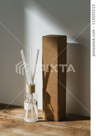 Elegant Reed Diffuser With Shadows on Wooden Surface in Soft Morning Light 114503213