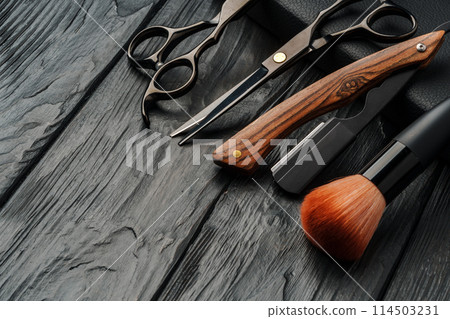 Hairdressing scissors on black wooden background close up Hairdressing scissors on black wooden background close up 114503231
