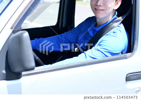 Male delivery driver driving 114503473