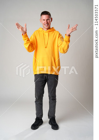 Portrait of surprised young man with shocked facial expression against gray background 114503571