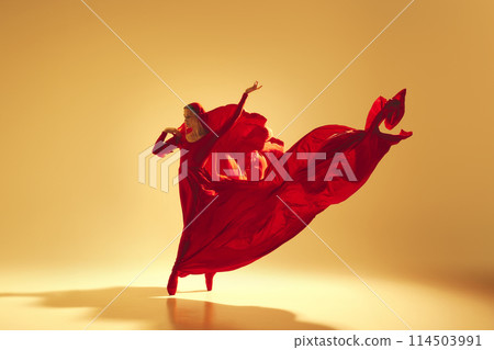 Lyrics of movement, Elegant woman, female dancer in red flowing dress with face covered dancing against sand color background Lyrics of movement, Elegant woman, female dancer in red flowing dress with face covered dancing against sand color background 114503991