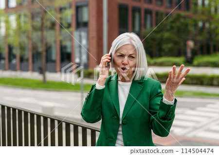 Mature businesswoman is angry, phone calling smartphone with business partner. Phone conflict, difficult customer. 114504474