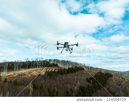 Aerial view of a drone moderning over forest, monitoring and analyzing in forestry management. Dron mapping forest after natural disaster assessing damage. 114504729