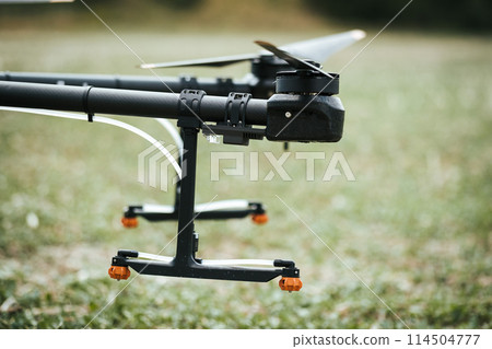 Close up of spray nozzles on agricultural drone. Dron spraying crops, distribute pesticides, herbicides and fertilizers efficiently and precisely. Modern farming. 114504777