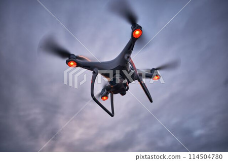 Aerial view of flying black drone, shot from below. 114504780