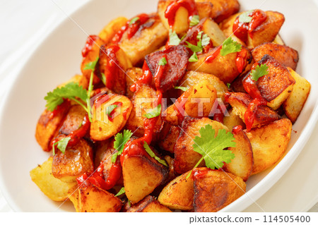 fried spanish potatoes with paprika sauce in bowl fried spanish potatoes with paprika sauce in bowl 114505400