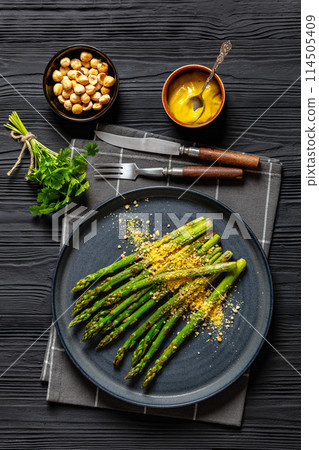 roasted asparagus with nut yeast crumble on plate 114505409
