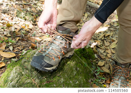A man's hands tying the laces of his hiking boots A man's hands tying the laces of his hiking boots 114505560