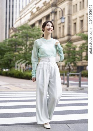 A smiling woman in her 30s walking down the street A smiling woman in her 30s walking down the street 114505642