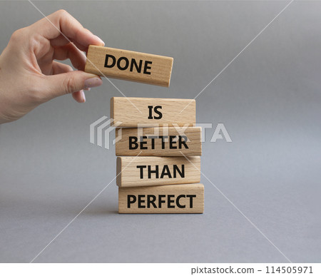 Done is better than Perfect symbol. Wooden blocks with words Done is better than Perfect. Beautiful grey background. Businessman hand. Business concept. Copy space. Done is better than Perfect symbol. Wooden blocks with words Done is better than Perfect. Beautiful grey background. Businessman hand. Business concept. Copy space. 114505971