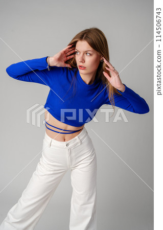 Young Woman model in Blue Top and White Pants posing on white background 114506743