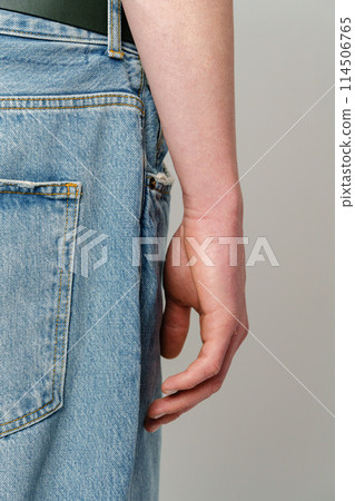 Close-Up of a Person With Arm Alongside a Denim Blue Jeans Pocket Close-Up of a Person With Arm Alongside a Denim Blue Jeans Pocket 114506765