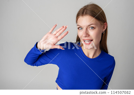 Young Woman in Blue Top Making Hand Gesture Young Woman in Blue Top Making Hand Gesture 114507082