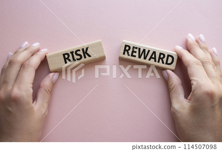 Risk or Reward symbol. Concept word Risk or Reward on wooden blocks. Businessman hand. Beautiful pink background. Business and Risk or Reward concept. Copy space Risk or Reward symbol. Concept word Risk or Reward on wooden blocks. Businessman hand. Beautiful pink background. Business and Risk or Reward concept. Copy space 114507098