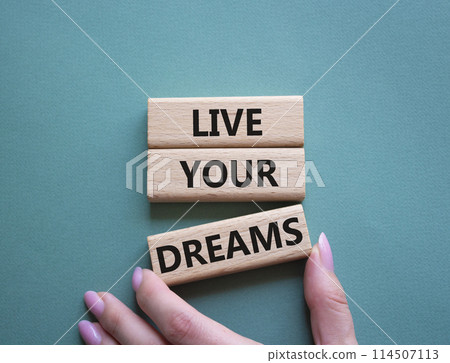 Live your Dreams symbol. Wooden blocks with words Live your Dreams. Beautiful grey green background. Businessman hand. Business and Live your Dreams concept. Copy space. 114507113