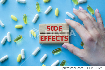 Side Effects symbol. Wooden blocks with words Side Effects. Beautiful blue background with pills. Doctor hand. Medicine and Side Effects concept. Copy space. 114507124