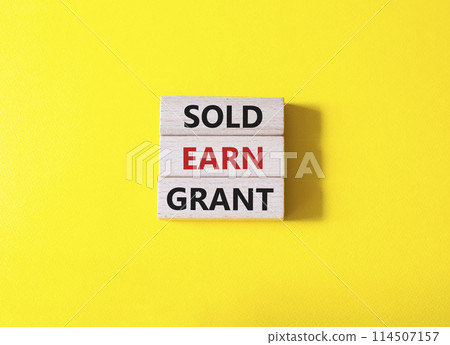 Sold Earn Grant symbol. Concept words Sold Earn Grant on wooden blocks. Beautiful yellow background. Business and Sold Earn Grant concept. Copy space. 114507157