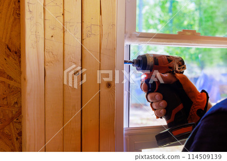 Installing plastic windows with screwdriver in new home by construction worker Installing plastic windows with screwdriver in new home by construction worker 114509139