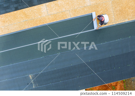 Installing new asphalt bitumen shingles on home roof Installing new asphalt bitumen shingles on home roof 114509214