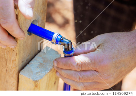 An experienced plumber connects blue PVC pipe to water piping system An experienced plumber connects blue PVC pipe to water piping system 114509274