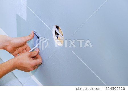 An electrician installed new current socket box during renovation of in apartment An electrician installed new current socket box during renovation of in apartment 114509320