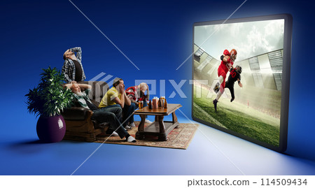Losing game. Emotional men sitting on couch at home, with beer and snacks, emotionally watching online match translation on 3D TV screen 114509434
