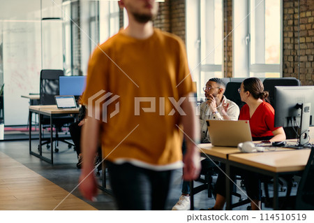 A diverse group of young business individuals congregates in a modern startup coworking center, embodying collaborative innovation and a dynamic atmosphere. 114510519