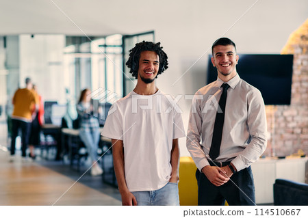 A group of colleagues, including an African American businessman and a young leader in a shirt and tie, pose together in a modern coworking center office, representing a dynamic blend of 114510667