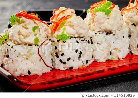 Elegant sushi roll with creamy seafood toppings and green tobiko Elegant sushi roll with creamy seafood toppings and green tobiko 114510929