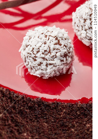 Coconut truffles on red glaze decorating handmade chocolate cake 114510949