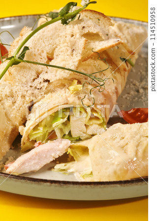 Chicken Caesar crepe rolls with sauce and parmesan on yellow 114510958