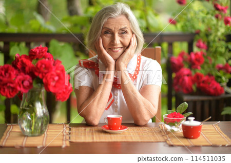 Portrait of a happy aged woman drinking coffee at home 114511035