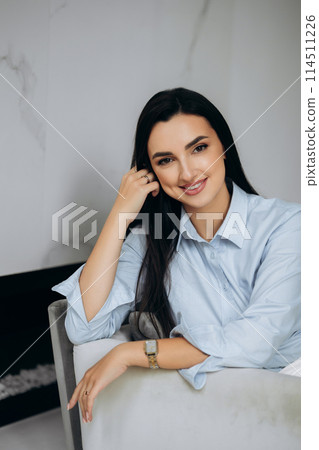 Portrait of businesswoman sitting in the chair in office. Formal clothes 114511226
