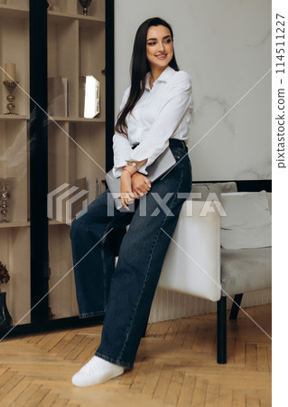 Attractive and stylish freelancer stand by chair with laptop. Female finish work. IT manager Attractive and stylish freelancer stand by chair with laptop. Female finish work. IT manager 114511227