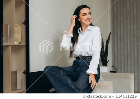 Office manager stand by chair in hall. Portrait of woman in white shirt. Happy lady during the break 114511229