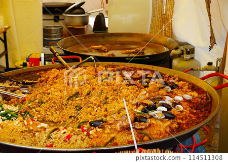 Paella cooked on a large iron plate Paella cooked on a large iron plate 114511308