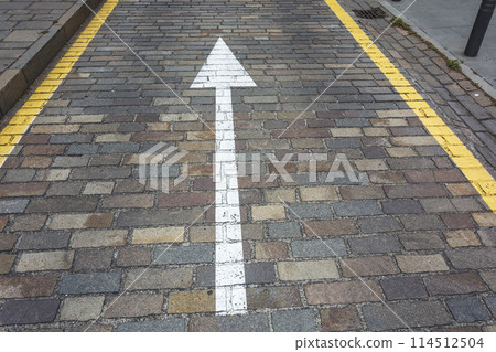 The white arrow on the road from the pavers indicates the direction of movement 114512504