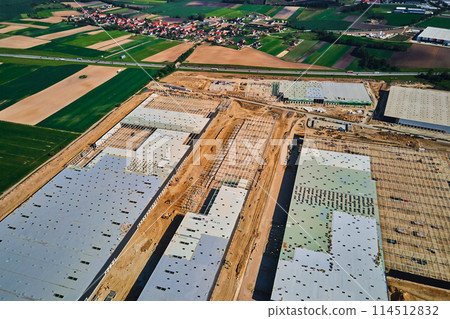 Construction site with steel frame structure of warehouse building, aerial view 114512832